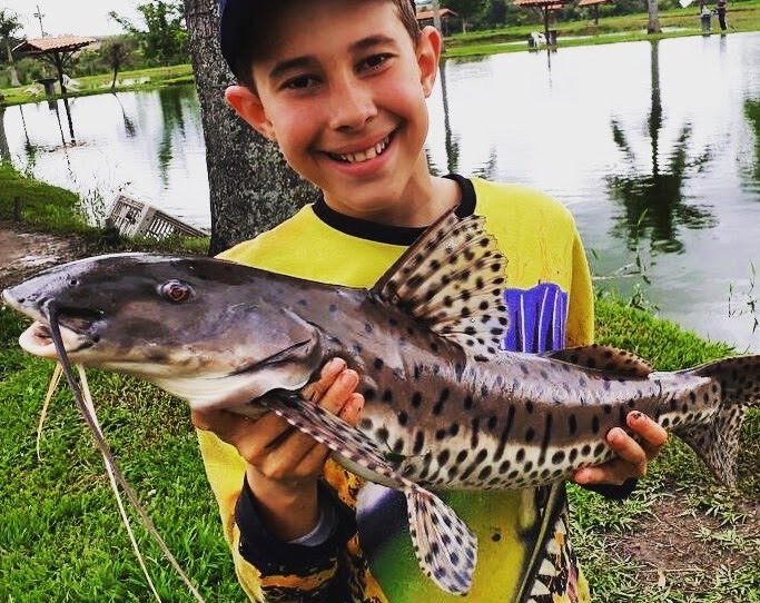 Jovem pescador com surubim na Vila Quatro Estações