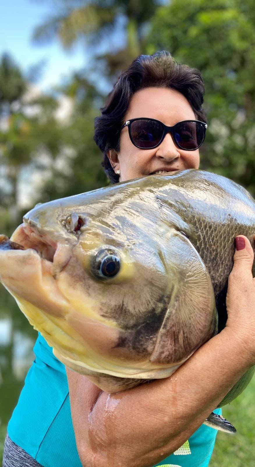 Pescadora com tambaqui pescado na Vila Quatro Estações