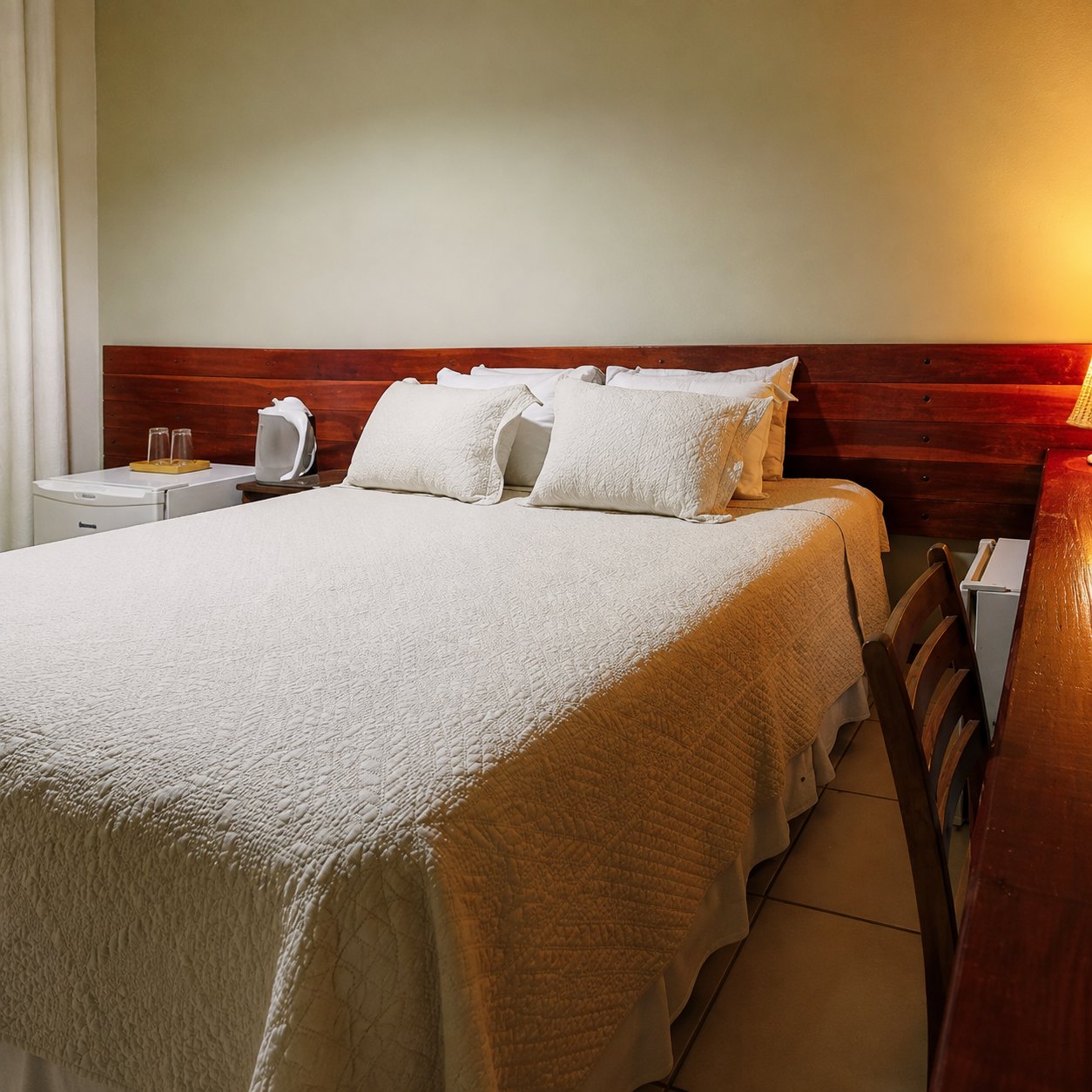Quarto com cama de casal e frigobar